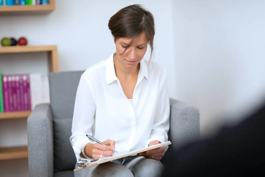 Svenja Schrankel in einem Therapiegespräch, Notizen machend